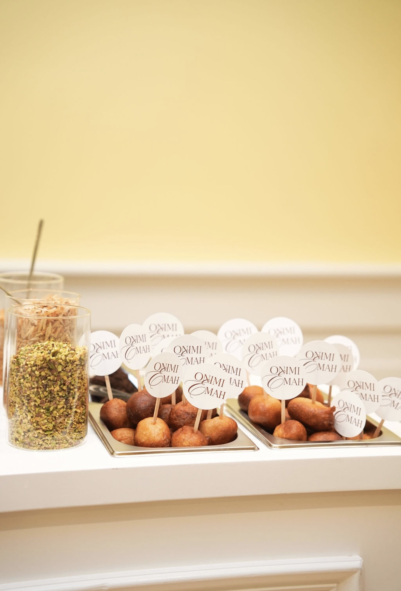 Trays of puff puff finished with round paper picks printed with the Onimi and Emah monogram.